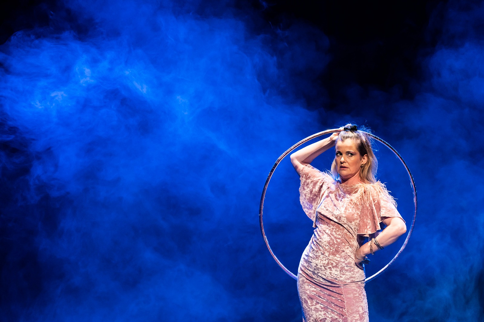 Amelia perfoming with a hoop in blue smoke.